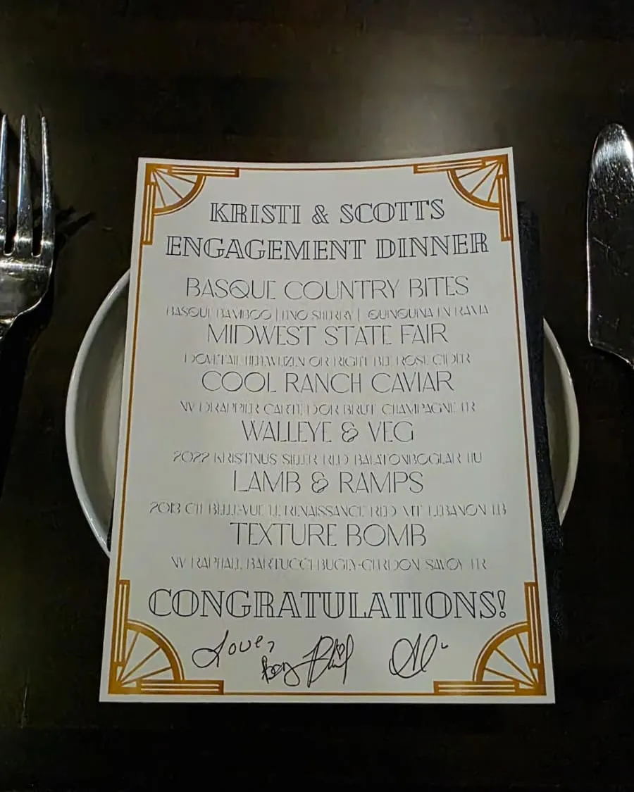 A place setting with a printed menu, fork and knife, at an engagement dinner