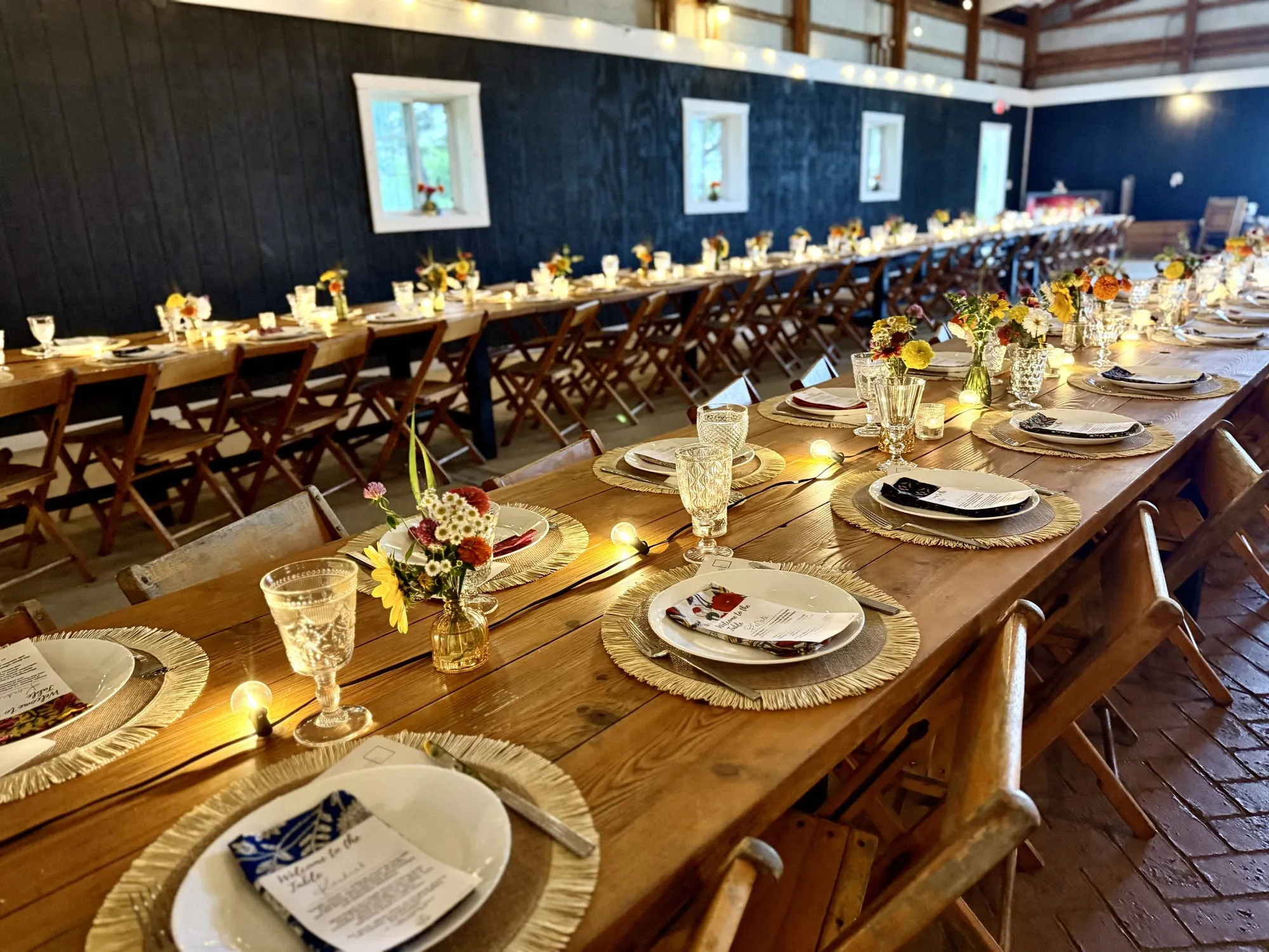 The long table set with wildflowers, candles, and glassware before guests arrive